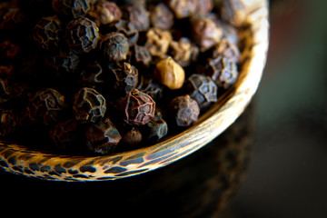 Black pepper in wooden spoon