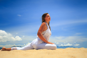 Fototapeta na wymiar blonde girl in lace in yoga asana left leg stretch on beach