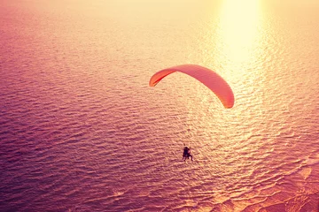 Papier Peint photo Lavable Sports aériens Silhouette of paraglider soaring over sea at sunset