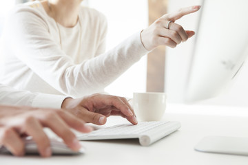 Men are entering the keyboard,Woman pointing finger monitor