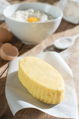 focus on butter, ingredients to make a cake on a wooden table