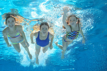 Obraz na płótnie Canvas Family swim in pool underwater, happy active mother and children have fun in water