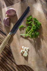 still life, a knife, garlic and  parsley on a wooden board