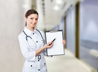 Portrait of a smiling nurse pointing to clipboard