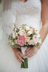 roses in hands of the bride. Focus on flowers