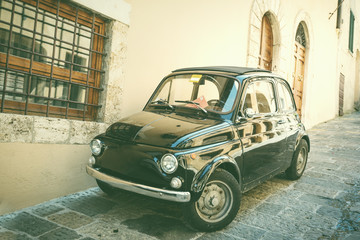 Old black car parked at the Italian street in a small town in Tu