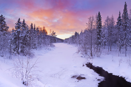 Sunrise over a river in winter near Levi, Finnish Lapland