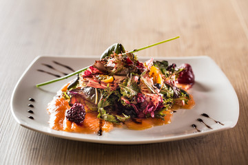 Salmon carpaccio on a wooden table.