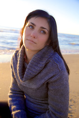 Woman thinking on the beach at sunset