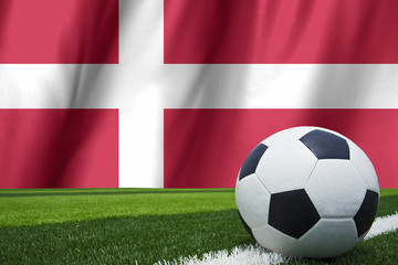 Fototapeta premium Soccer ball and national flag of Denmark lies on the green grass