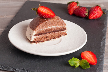 Chocolate cake with strawberry on wooden table, horizontal