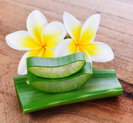 Aloe vera and frangipani flower on wooden