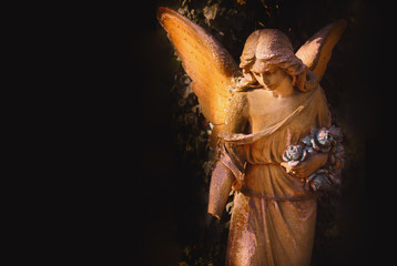 sculpture of an angel with dark background