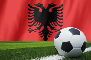 Soccer ball and national flag of Albania lies on the green grass