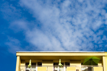 Green umbrella on the balcony, summer in the city