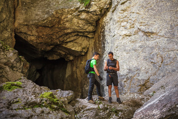Hikers standing at the entrance of a cave