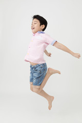 Happy asian boy is jumping at studio.