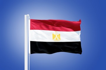 Fototapeta na wymiar Flag of Egypt flying against a blue sky
