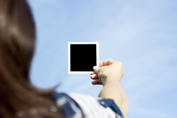 Girl hand holding a instant photo