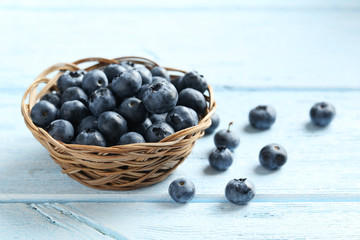 Blueberries in basket on a blue wooden background