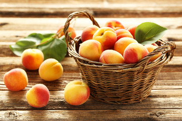 Fresh apricots in basket on a brown wooden background