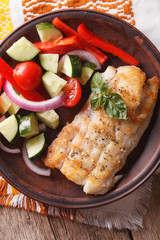 grilled fillet of fish and vegetable salad close-up. vertical top view
