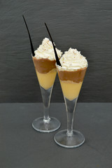 Dessert served in beautiful glasses, with cream and cinnamon on top.