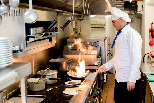 Chef with burning flames on kitchen