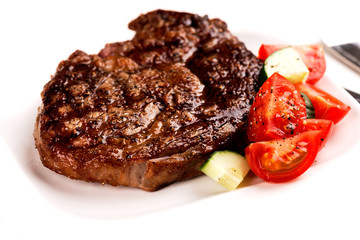 Grilled steak and vegetables on white plate