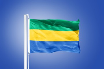 Flag of Gabon flying against a blue sky