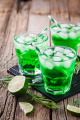 Green tarragon drink with  ice cubes, selective focus