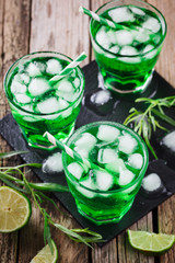 Green tarragon drink with  ice cubes, selective focus
