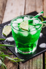 Green tarragon drink with  ice cubes, selective focus