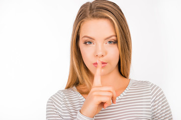 Naklejka premium Serious girl in shirt holding finger on lips
