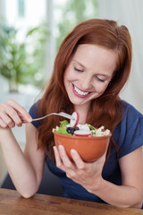 lächelnde frau isst salat