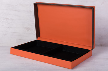 Open orange gift box on grunge wood background