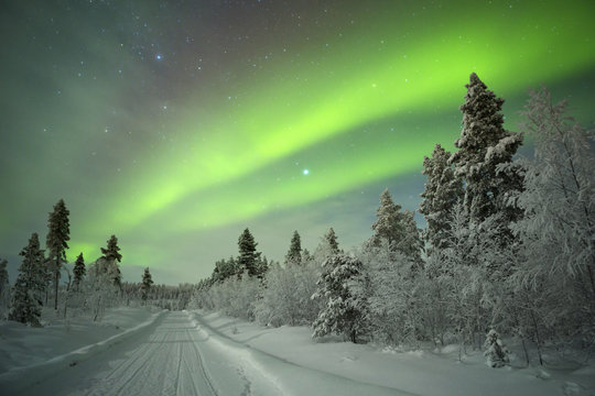 Aurora borealis over winter landscape in Finnish Lapland.