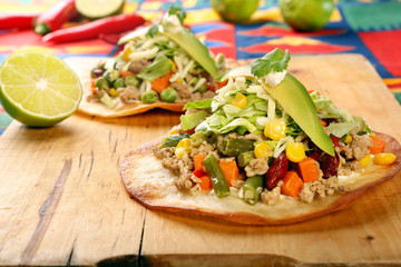 Tostadas with ground beef and vegetables on wooden background