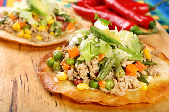 Tostadas with ground beef and vegetables on wooden background