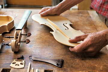 Elderly person building a violin