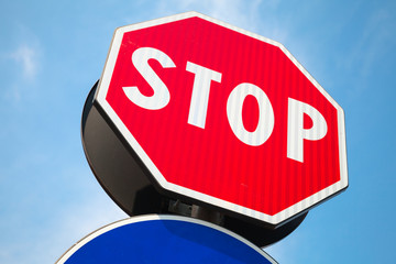 Classical red Stop road sign over blue sky