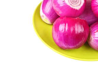 Peeled red onion on plate, isolated on white background