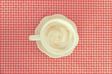 Top view of coffee cup on the red color table cloth , Soft pastel effect