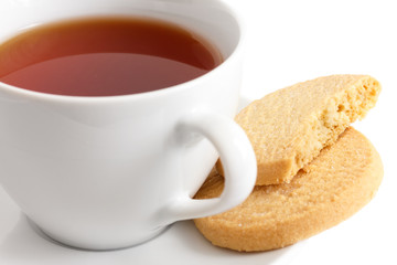 Detail of a white ceramic cup of rooibos tea with shortbread bis