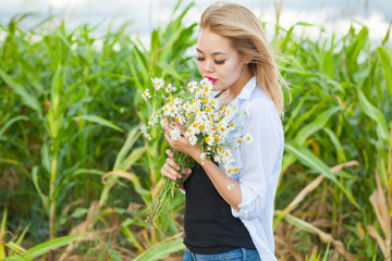 Fototapeta premium asian woman with bouquet of camomilles
