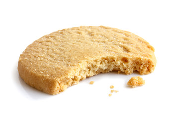 Single round shortbread biscuit with crumbs and bite missing. In