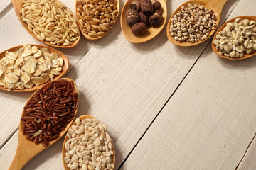 cereals in the spoons on the white wooden table background
