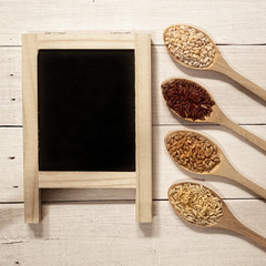 cereals in the spoons on the white wooden table

