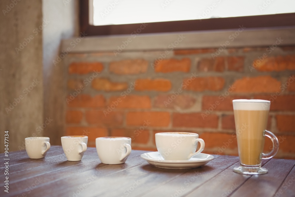 Wall mural several hot beverages in a row on wooden table