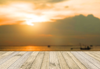 perspective wood plank floor or walk way on over blur sea above sunset background